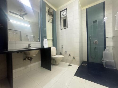 a bathroom with a sink and a toilet and a shower at JK Rooms 149 Thakur Galaxy in Nagpur