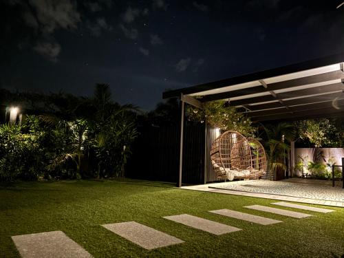 a patio at night with a grass yard at Large Mt Maunganui Family Villa in Mount Maunganui