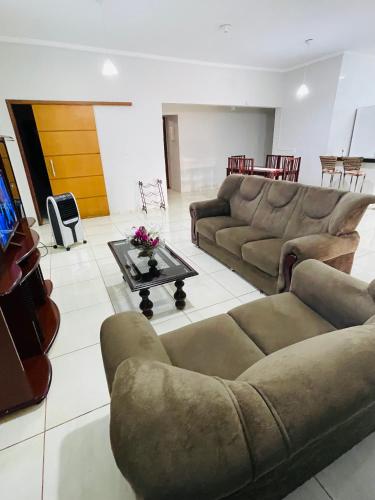 a living room with two couches and a tv at Casa Coqueiros in Barretos