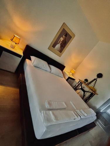 a bedroom with a large white bed with two lamps at Villa Srna Apartments 