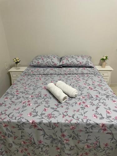 a bed with two pillows and two towels on it at Casa Coqueiros in Barretos