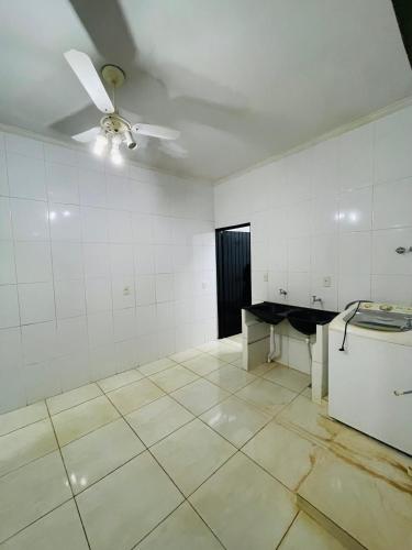 an empty room with a ceiling fan and a refrigerator at Casa Coqueiros in Barretos
