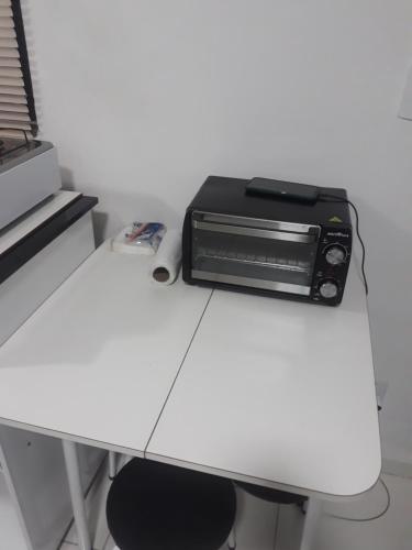 un tostapane in forno seduto sopra un tavolo bianco di Studio a Coroa Vermelha