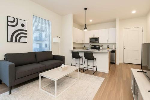 a living room with a couch and a kitchen at Boulevard Stays Modern Tempe 1BR ASU Pool Gym 14 in Tempe