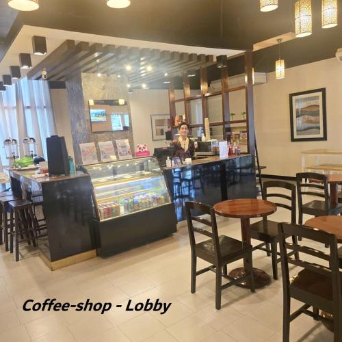 a coffee shop with a woman standing at a counter at La Mirada Residences in Mactan