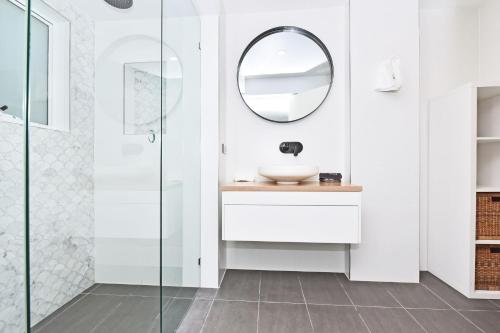 a white bathroom with a sink and a mirror at Boat Harbour Beach House in Boat Harbour