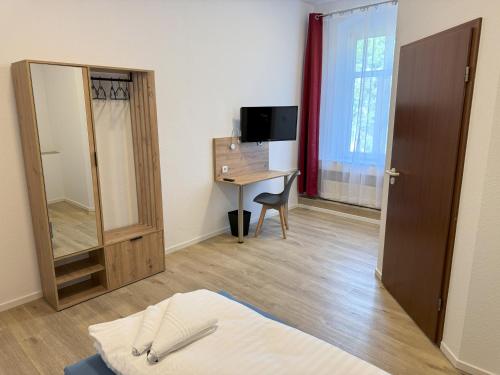 a room with a bed and a desk and a mirror at CityScape Hotel in Chemnitz