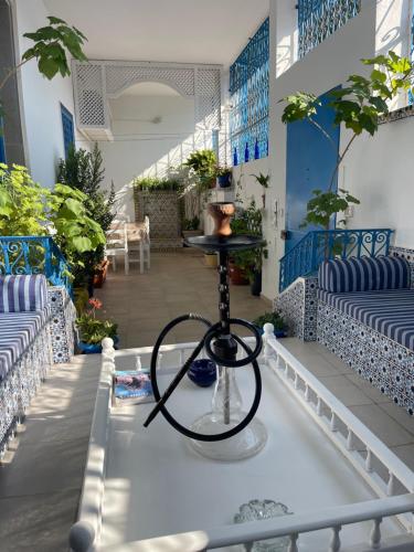 a stage with a stand in a room with plants at BALKIS La RÊNE DE SABA in Sidi Bou Saïd
