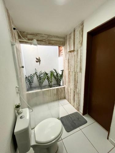a bathroom with a toilet and a window at Casa Naurú in Fortim