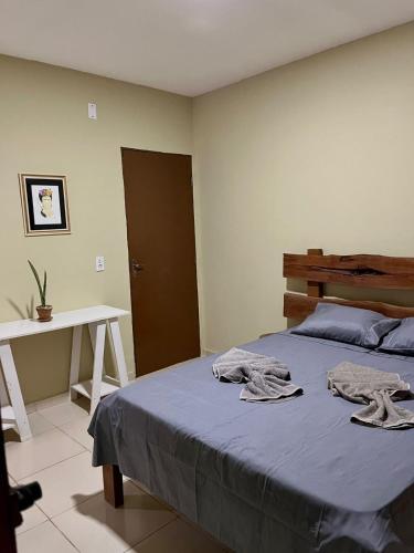 a bedroom with a bed with two towels on it at Casa Naurú in Fortim