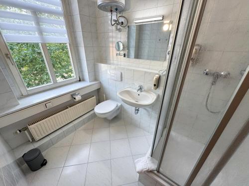 a bathroom with a toilet and a sink and a shower at CityScape Hotel in Chemnitz
