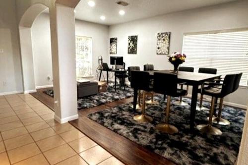 a dining room with a table and chairs on a rug at StayCation Away in Humble