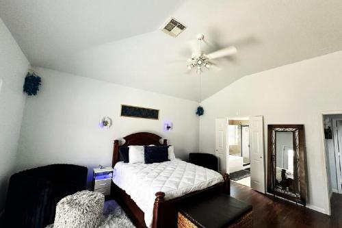 a bedroom with a bed and a ceiling fan at StayCation Away in Humble