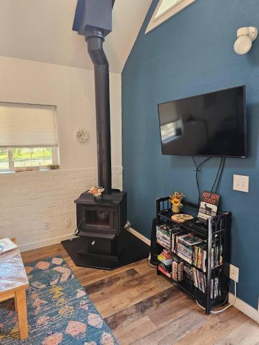 a living room with a wood stove and a tv at Cozy Cabin, near Mosier and Hood River in Mosier