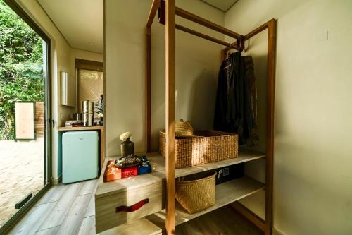 La MajahuaMinimalist Surf, Pool, AC, Icebath, Yoga, Saladita, 50m to Surf的一间设有镜子和篮子架的房间