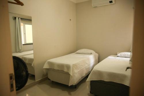 a small room with two beds and a window at La Casa Lagoinha in Tigre
