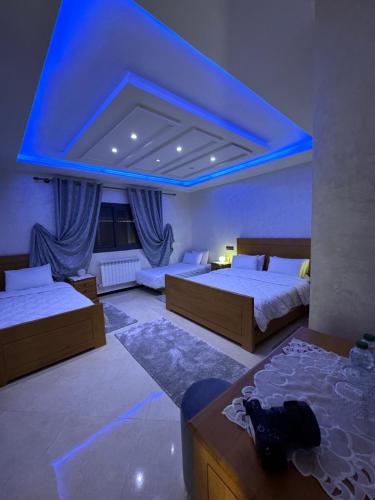 a bedroom with two beds and a blue ceiling at Moonrise Villa VIP Midelt in Midelt