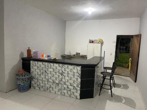 una cocina con una encimera con un refrigerador y una silla en Chácara recanto do girassol, en Aquiraz