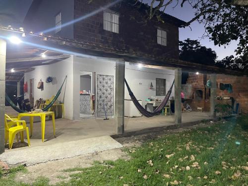 Un patio con mesas y sillas amarillas frente a una casa. en Chácara recanto do girassol, en Aquiraz