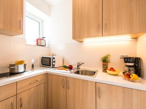 a kitchen with a sink and a microwave at Pension Lahn in Rablà