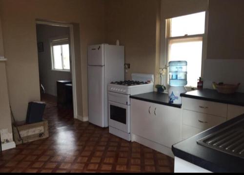 y cocina con fogones blancos y nevera. en Wirraminna Station Accommodation, 