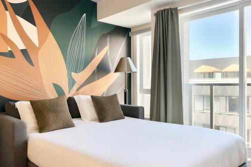 a bedroom with a white bed and a large window at The 708 - For 4 - Free Parking - BBQ in Quebec City