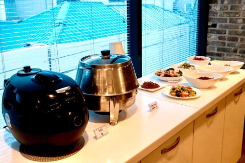 a counter with a pot and plates of food on it at 호텔 인썸니아 Hotel Insomnia 失眠酒店 in Daegu