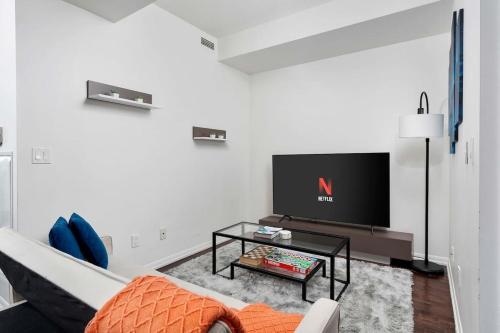 a living room with a tv and a couch at Stylish Condo with Private Patio in Fortyork in Toronto