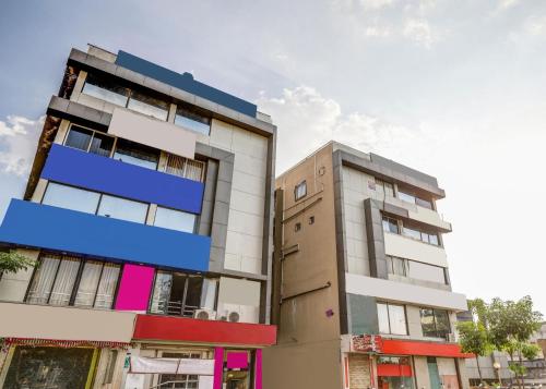 a building with a blue sign on the side of it at Hotel O Maple view in Naroda