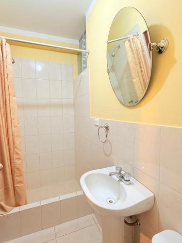 a bathroom with a sink and a mirror at Hostal La Alborada in Cajamarca