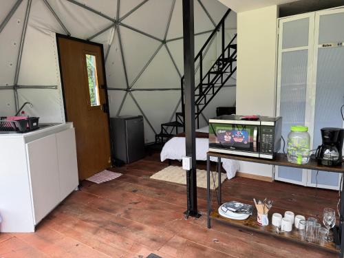a room with a tent with a table with a microwave at Domo Nool con vista a las estrellas in Río Blanco