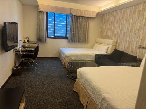 a hotel room with two beds and a television at Fairy Tale City Motel in Hualien City