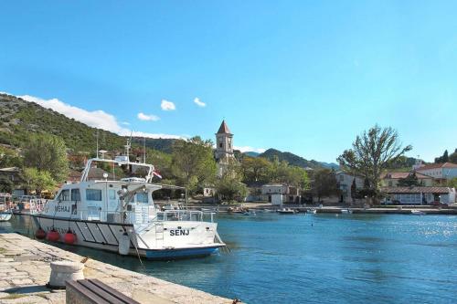 a boat is docked at a dock in the water at Apartments by the sea Sveti Juraj, Senj - 2399 in Sveti Juraj