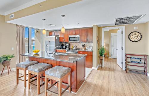 a kitchen with a large island with bar stools at Honua Kai Resort And Spa By Maui Resort Rentals in Lahaina