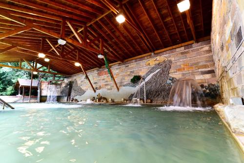 einen Pool mit einem Brunnen in einem Gebäude in der Unterkunft Jenq Yang Hotspring Hotel in Renai