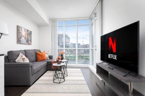 a living room with a large flat screen tv at Downtown Escape Stylish Condo with City Views in Toronto