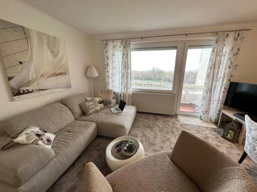 a living room with a couch and a tv at Modern, Gemütlich, Strandnah in Cuxhaven