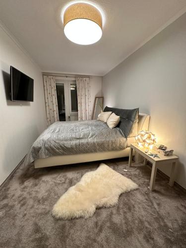 a bedroom with a bed and a table with a rug at Modern, Gemütlich, Strandnah in Cuxhaven