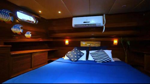 a bedroom in a boat with a bed and a tv at IBIZA Escuna in Paraty