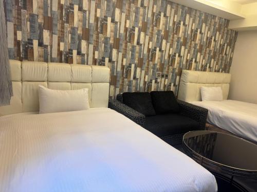 a hotel room with two beds and a chair at Fairy Tale City Motel in Hualien City