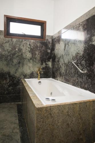 a bathroom with a bath tub with a window at Hotel Boutique Vista Velero in Viña del Mar