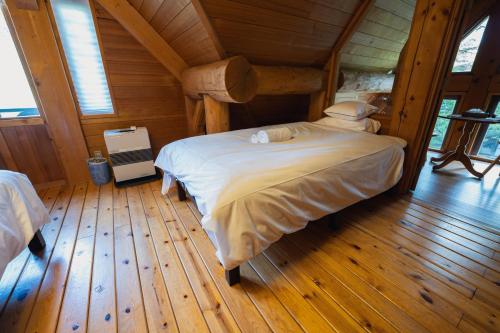 a bedroom with a large bed in a cabin at Hakuba Riverside Loghouse in Hakuba