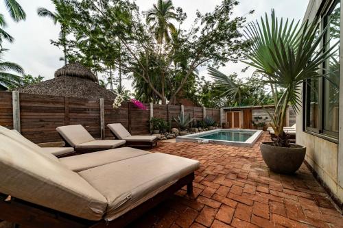 a patio with a couch and chairs and a pool at Surf Retreat La Saladita, Yoga, Pool, Templo in La Majahua