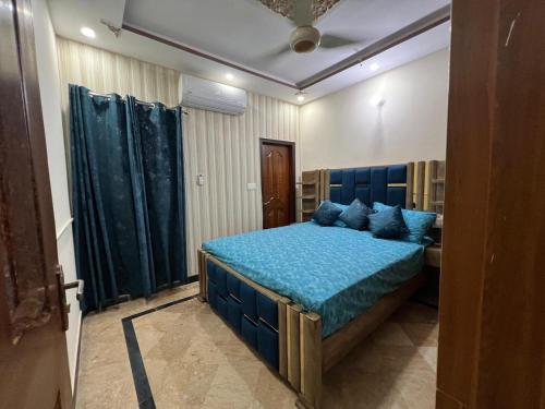 a bedroom with a blue bed with blue pillows at Comfort Luxury home in Lahore