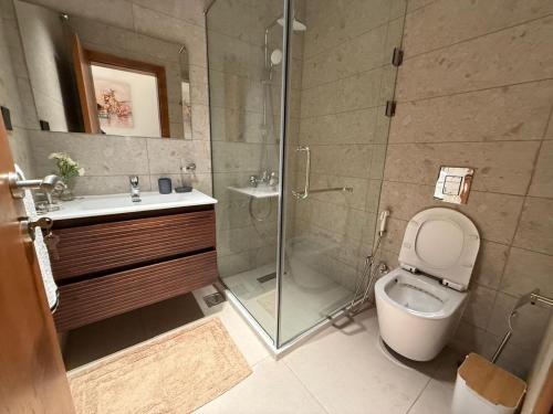 a bathroom with a shower and a toilet and a sink at JEYA Luxury-Accra in Accra