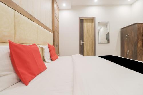 a bedroom with a large white bed with red pillows at Hotel O Citywalk in Zirakpur