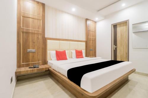 a bedroom with a large white bed with red pillows at Hotel O Citywalk in Zirakpur