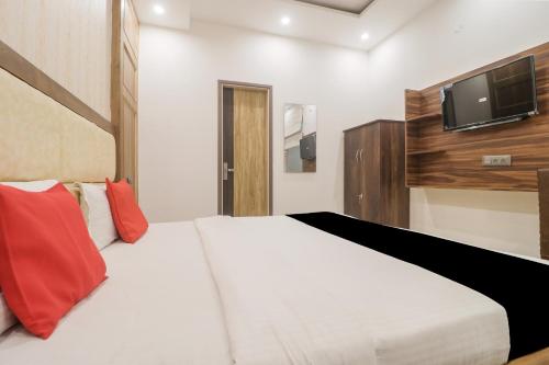 a bedroom with a bed with a tv on the wall at Hotel O Citywalk in Zirakpur