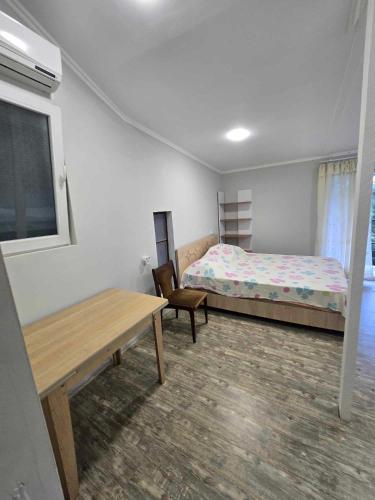 a bedroom with a bed and a table and a bench at Guesthouse "Pines" in Urekis Sadguri