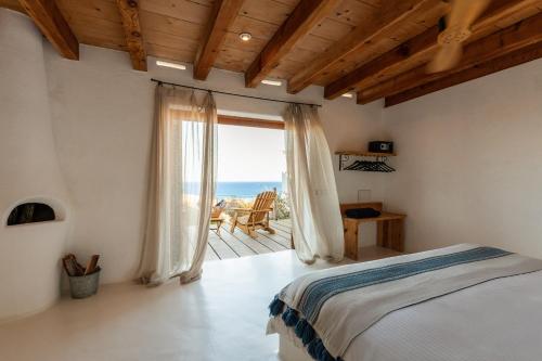 a bedroom with a bed and a view of the ocean at NEST Baja in San José del Cabo